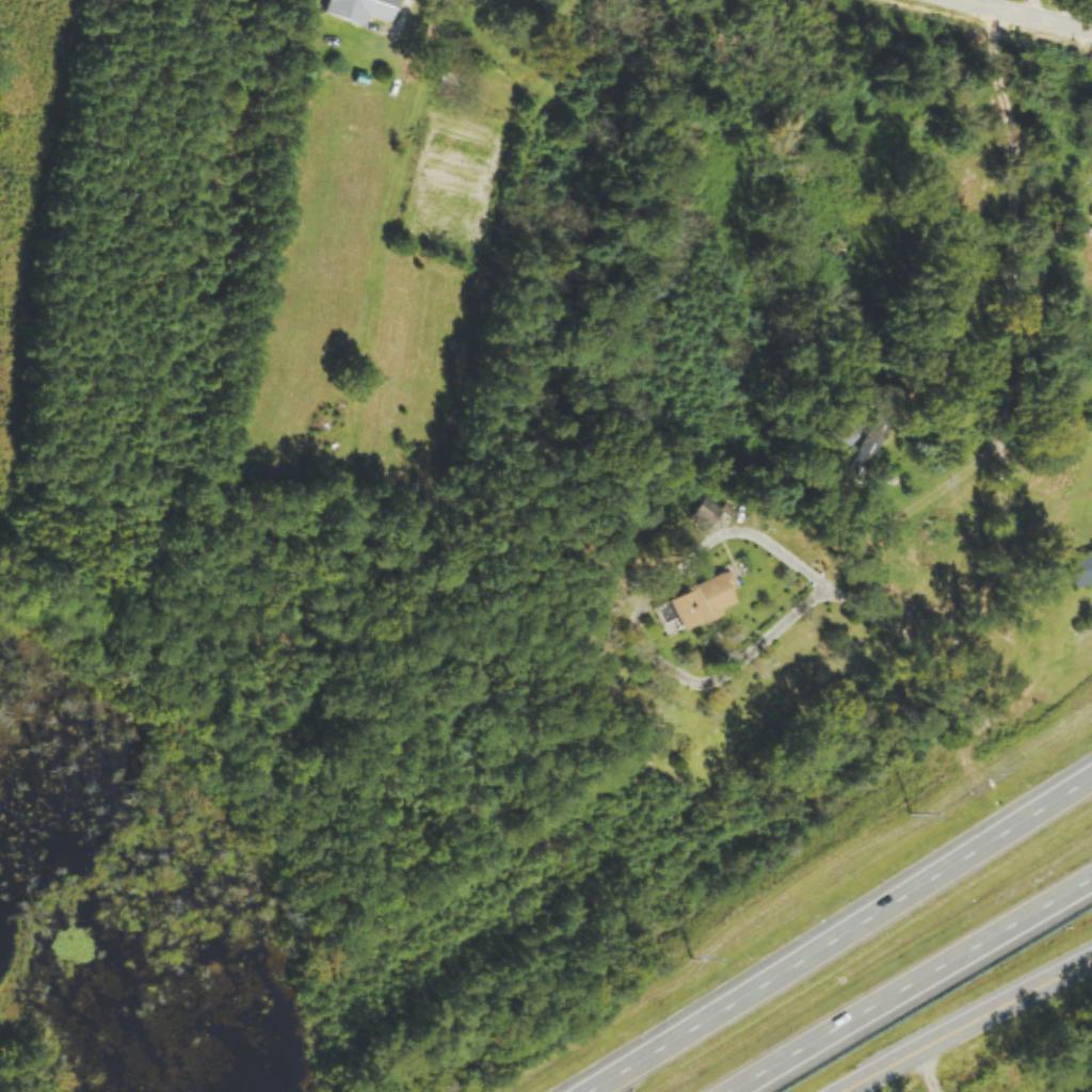 Aerial of wooded acreage beside a highway